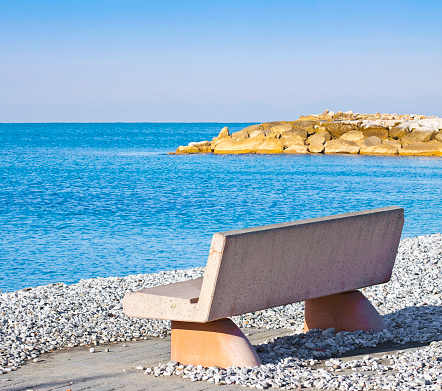 Concrete bench by the sea with calm water
