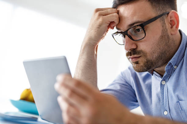 istock Worried man working on a touchpad at home office. 1434639406