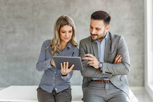 istock Young business couple reading an e-mail on touchpad in the office. 1434640067