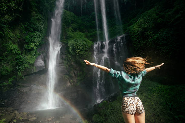 istock Young woman backpacker looking at the waterfall in jungles. 1434644597