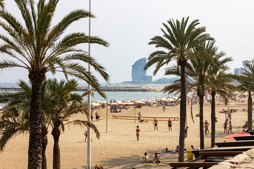 Barcelona, Spain – June 29, 2012: A group of tourists at Somorrostro beach in Barcelona, Spain