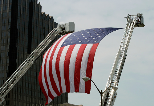 Large American Flag hanging between Firefighter truck Ladders in Indianapolis, Indiana.