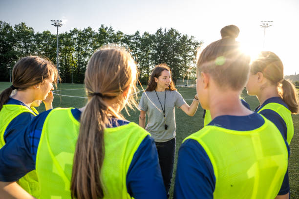 Coach instructing to football players