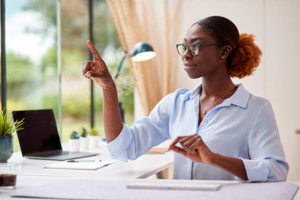 istock Woman Working From Home Office Sitting At Desk Interacting With AR Or VR Technology 1434650943