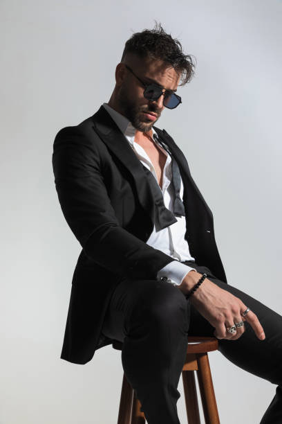 istock attractive elegant groom with open bowtie looking to side and posing 1434652696