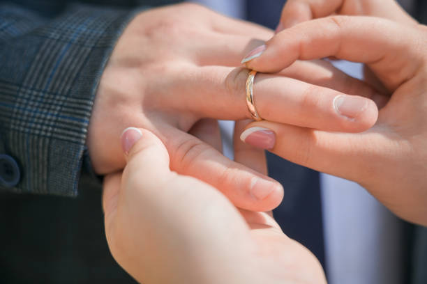 istock A woman puts a wedding ring on a man's finger. Close-up. 1434652904