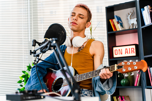 transgender person Blogger and radio host playing a song and singing for some of his fans during a live podcast for social media