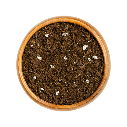 Organic potting compost, in a wooden bowl. Soft soil, growing medium and culture substrate, for sowing. Made of moderately decomposed raised bog peat, bark humus, wood fibers, sand and NPK-fertilizer.
