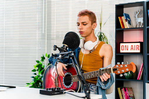 transgender person Blogger and radio host playing a song and singing for some of his fans during a live podcast for social media