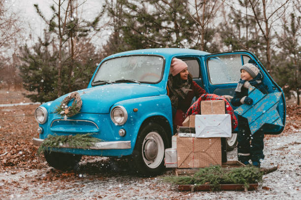 istock child Decorated with a blue retro car with festive Christmas tree branches, gift boxes in craft wrapping paper, a wreath of pine fir needles. 1434657999