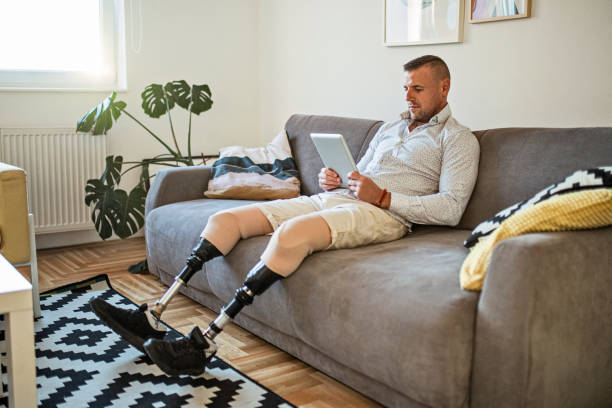 istock Young man with amputee legs using digital tablet at home 1434658304