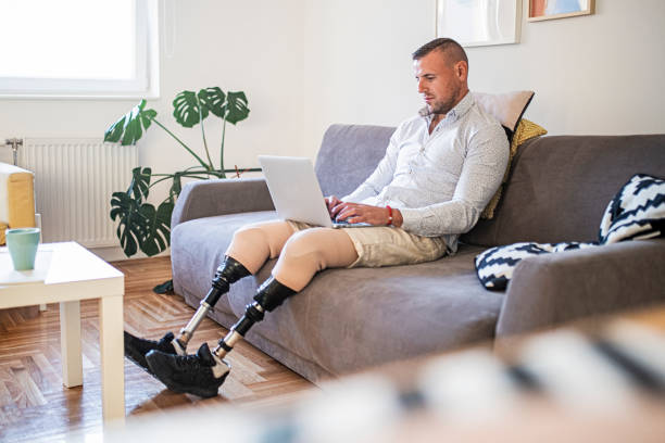 istock Young man with amputee legs typing on laptop 1434658311