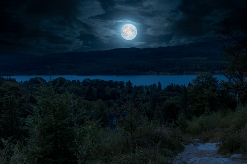 Digitally enhanced view of moonlit Loch Achray from the path leading down from Ben A’an, near Brig o’ Turk in The Trossachs, Scotland, UK