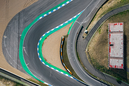 Aerial top down drone view of an empty racing track with tight turns and hairpins