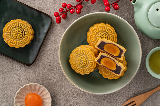 Delicious Cantonese moon cake for Mid-Autumn Festival food mooncake on gray table background for afternoon tea, holiday celebration serving.