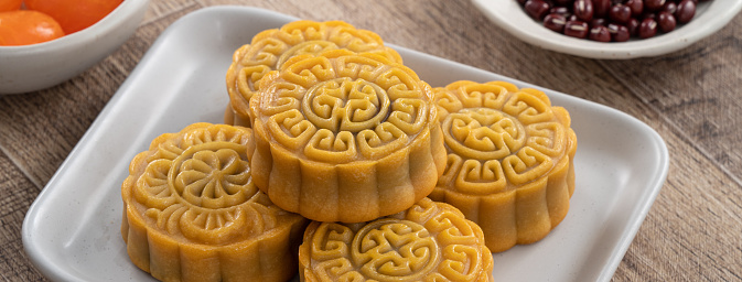 Delicious Cantonese moon cake for Mid-Autumn Festival food mooncake on wooden table background for afternoon tea, holiday celebration serving.