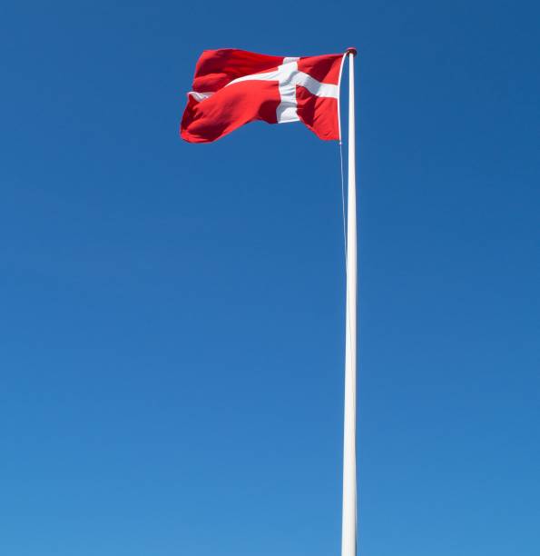 istock Low angle shot of a white pole with a Danish flag in the blue sky 1434660079