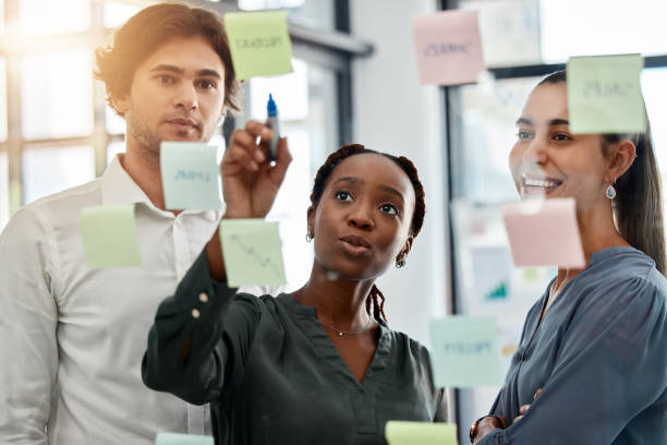 istock Working, post it planning and teamwork collaboration with notes of a office work team. Business strategy, corporate schedule or marketing moodboard of staff with diversity busy with a job project 1434660332
