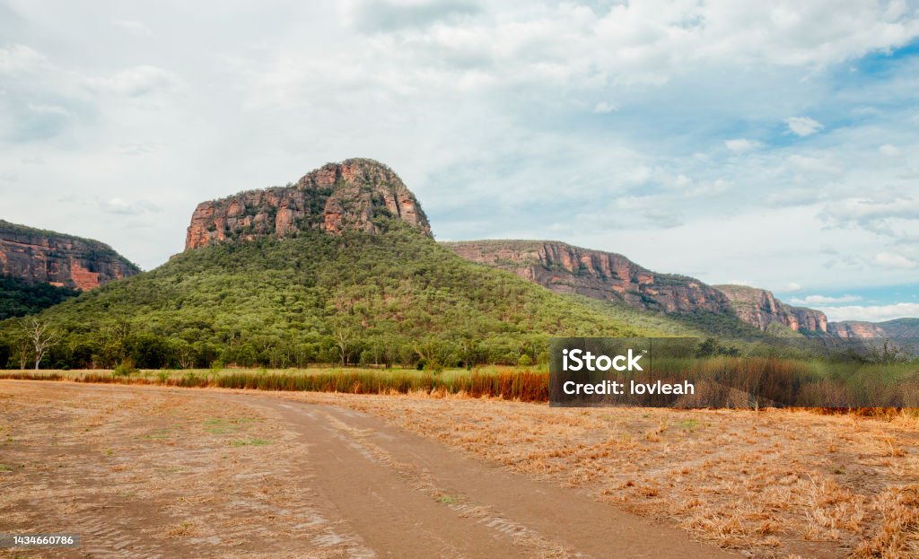 Dirt road in Capertee Valley with rising rocky mountain in distance Australia Stock Photo