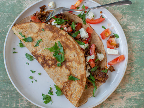 Savory pancake with ground beef, onion, tomatoes and feta cheese stock photo