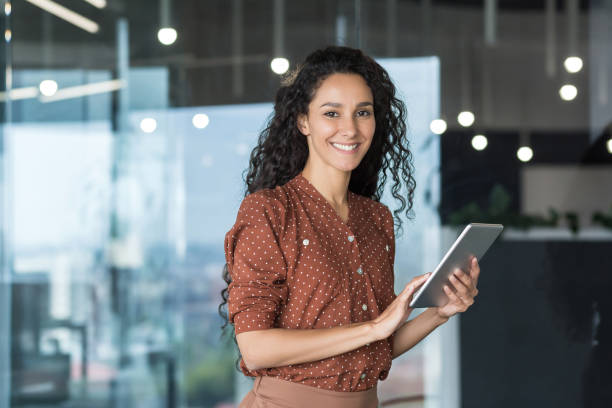 jovem e bem sucedida programador feminina, retrato de engenheira com funcionária de startup de computador tablet trabalhando dentro do prédio do escritório usando tablet para aplicativos de teste sorrindo olhando para a câmera - promotor imobiliário - fotografias e filmes do acervo