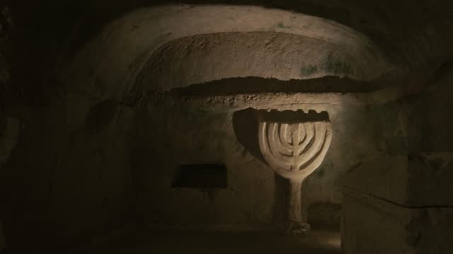 Menorah on the wall in construction ancient building made of sand and stone - the inside view