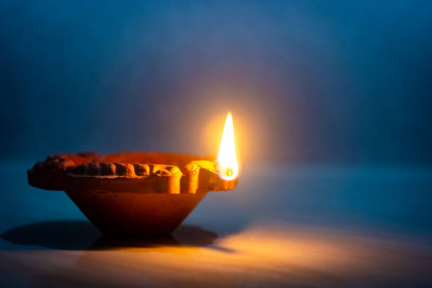 Happy Diwali - Clay diya lamp lit during diwali celebration Happy Diwali - Clay diya lamp lit during diwali celebration clay oil lamp stock pictures, royalty-free photos & images
