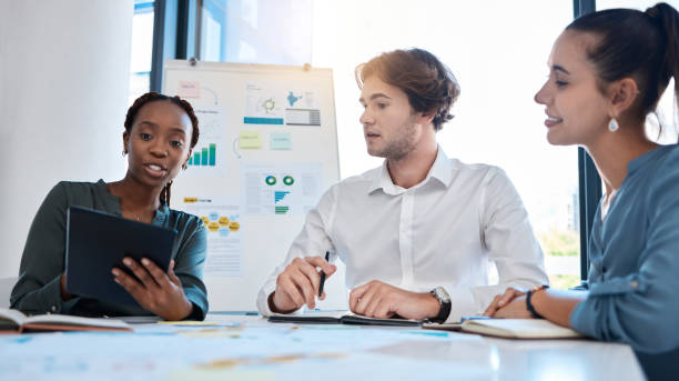 istock Business team, analytics and collaboration meeting with tablet for marketing plan in teamwork at the office. Group of people in market analysis strategy, planning and paperwork having a discussion 1434667190