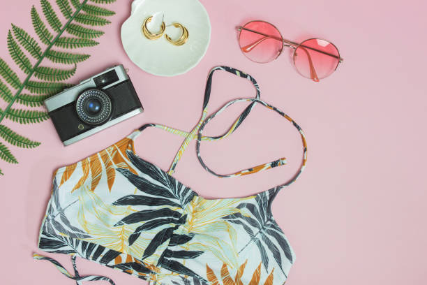 istock Beach concept with camera, sunglasses, green leave and hat over the pink background. 1434667989