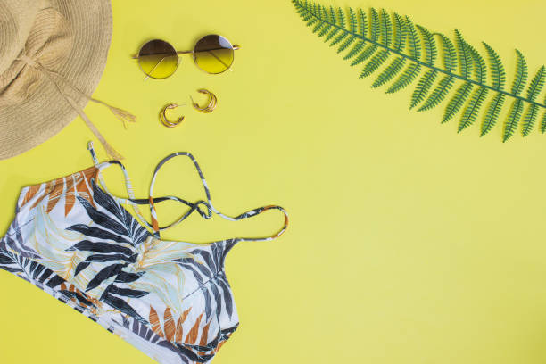 istock Beach concept with camera, sunglasses, green leave and hat over the yellow background. 1434668049