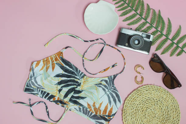 istock Beach concept with camera, sunglasses, green leave and hat over the pink background. 1434668439