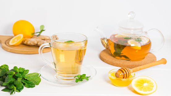 Mint tea in a glass teacup against blue background on a table with copy space