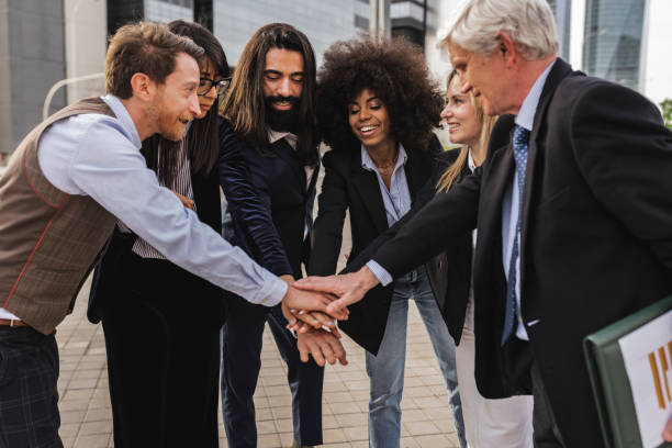 istock Multiracial business team joining hands together while standing outdoors in front of office building 1434675786
