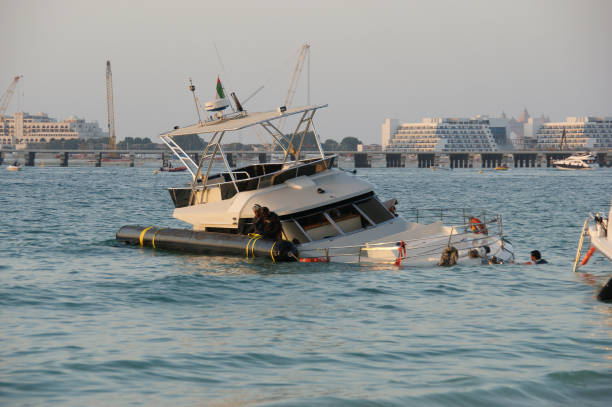 yacht coulé près de la marina de dubaï. travaux de sauvetage sur le relevage du yacht coulé - sunken photos et images de collection