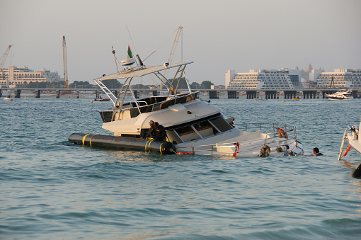 Dubai, United Arab Emirates - January 5, 2019: Sunken yacht near Dubai Marina. Rescue work on raising the sunken yacht