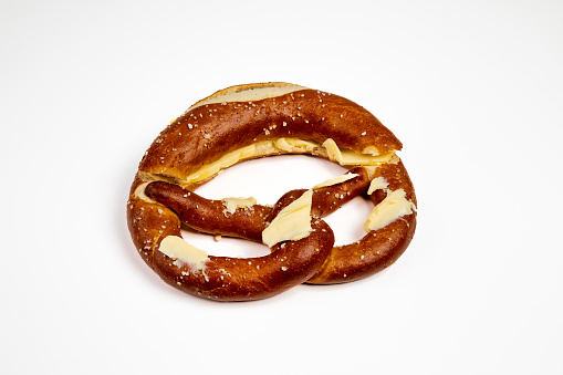 German pretzel with butter and salt isolated on white background.