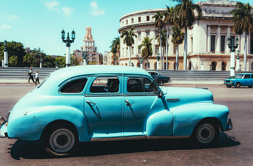 Old American car driving at a street of Havana, Cuba