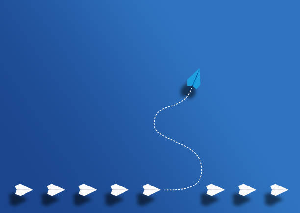 paper planes in a row and one paper glider going in different direction above blue background paper planes in a row and one paper glider going in different direction above blue background, breaking new ground and stepping out of the line concept individuality stock pictures, royalty-free photos & images
