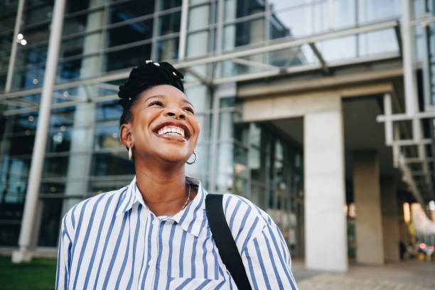 Young ambitious black businesswoman smiling happily while commuting to work in the morning stock photo