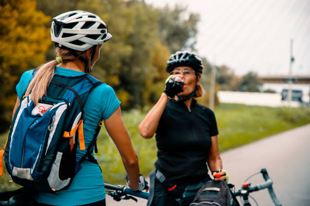 dojrzałe kobiety jeżdżące na rowerze w mieście - senior adult cheerful adventure discovery zdjęcia i obrazy z banku zdjęć