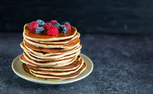 istock Pancakes with berries and honey on dark background with copy space 1434688046