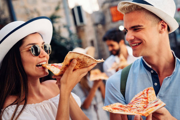 istock Group of friends eating pizza while traveling on vacation 1434688423