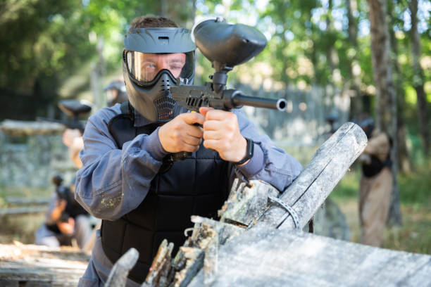 istock Paintball player in protective uniform aiming and shooting with guns 1434690223