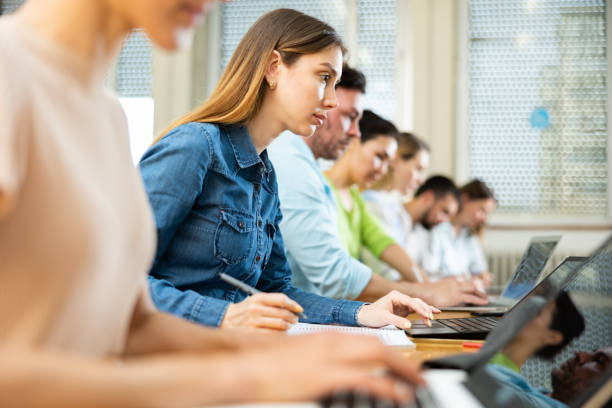 istock Group of students searches for information on a laptop and writes it out 1434690808