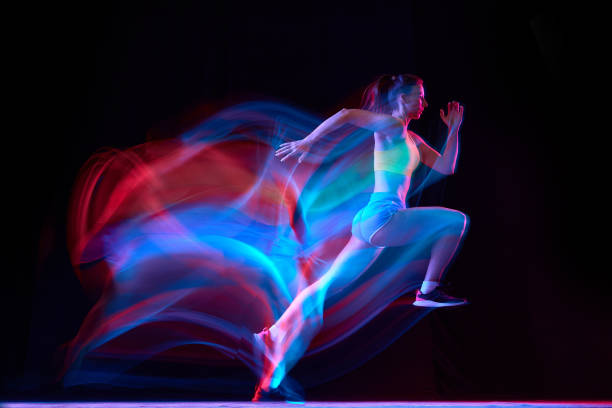 istock Professional female athlete, runner in motion over dark background in mixed neon light. Art, beauty, sport, cyberpunk concept 1434691766