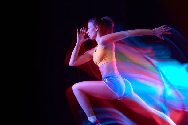 istock Speed. Professional female athlete, runner in motion over dark background in mixed neon light. Art, beauty, sport, cyberpunk concept 1434691776