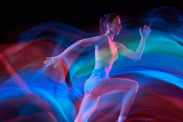 istock Glow. Professional female athlete, runner in motion over dark background in mixed neon light. Art, beauty, sport, cyberpunk concept 1434691805