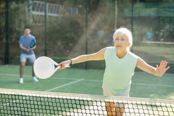 istock Active elderly woman playing padel tennis on open court 1434693321