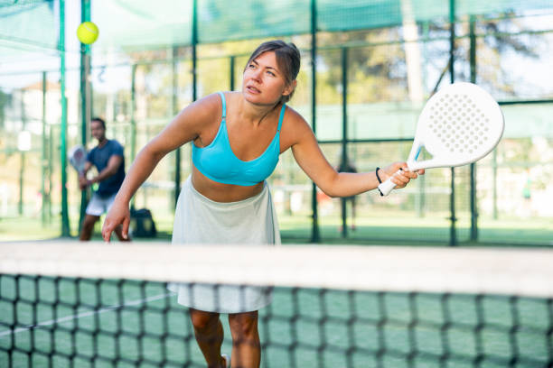 istock Young female paddle tennis player performing left-handed forehand 1434694040