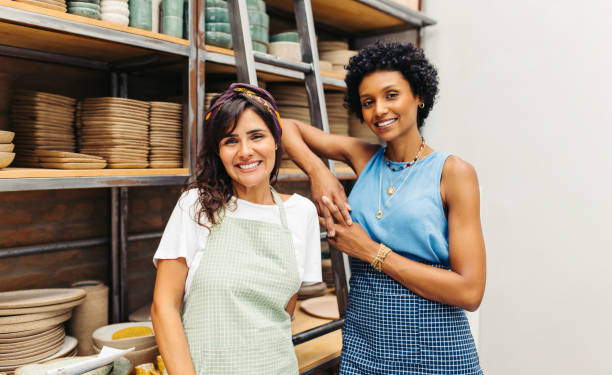 istock Happy female potters smiling at the camera in their workshop 1434694311